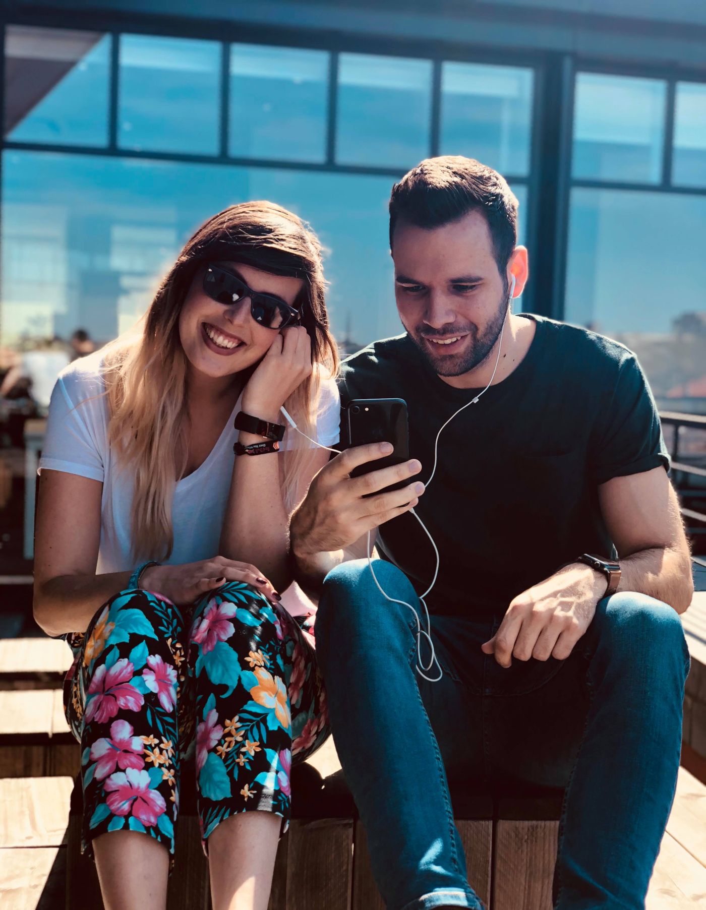 A couple smiling as they listen to music together